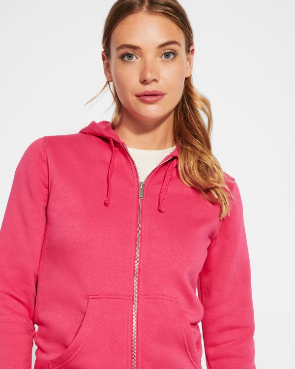 Miliar Ropa Laboral Sudadera de mujer con capucha forrada a tono. Cremallera metálica frontal y bolsillo estilo canguro. Cubrecosturas reforzado en el cuello interior, corte entallado, y punto canalé 2x2 en puños y cintura.