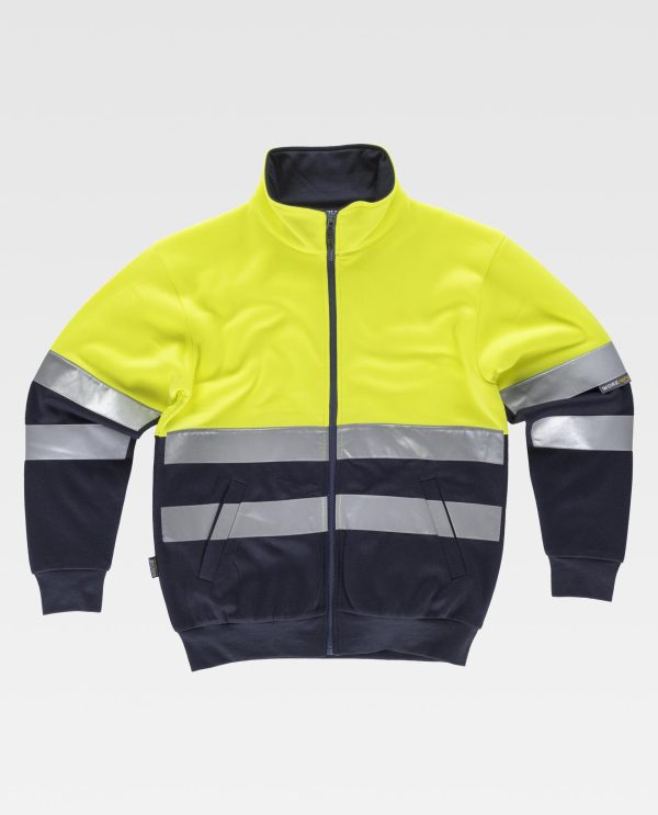 Miliar Ropa Laboral Sudadera combinada con cintas reflectantes. Cuello alto con cierre de cremallera y costuras reforzadas. Parte superior de alta visibilidad. Dos bolsos laterales interiores. Dos cintas reflectantes en pecho, espalda y mangas. Suave y cálido acabado en el interior. Puños y cintura elásticos en punto canalé.