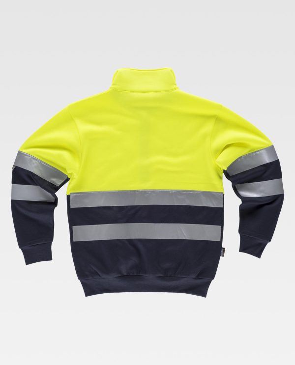 Miliar Ropa Laboral Sudadera combinada con cintas reflectantes. Cuello alto con cierre de cremallera y costuras reforzadas. Parte superior de alta visibilidad. Dos bolsos laterales interiores. Dos cintas reflectantes en pecho, espalda y mangas. Suave y cálido acabado en el interior. Puños y cintura elásticos en punto canalé.