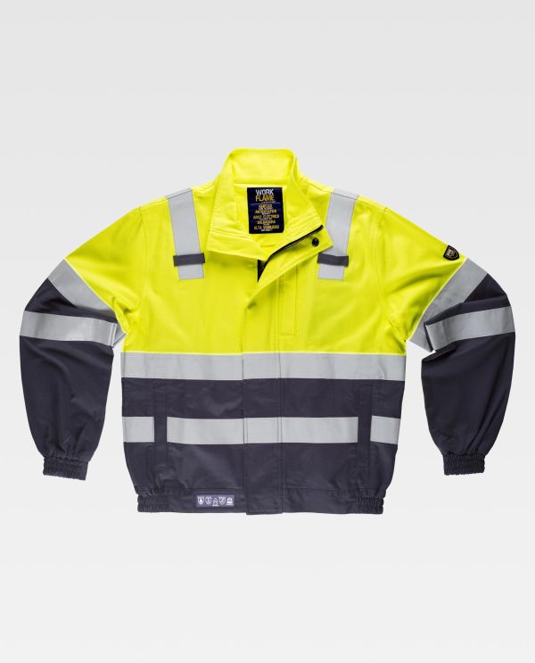 Miliar Ropa Laboral Cazadora ignífuga, antiestática con protección para soldadura, arco eléctrico y contra productos químicos, de alta visibilidad con cintas reflectantes. Cuello alto y cierre de cremallera de metal y corchetes ocultos por solapa postiza. Un bolso de pecho y dos bolsos laterales, todos de ojal con solapa de seguridad y corchete oculto. Una cinta reflectante ignífuga en hombros y dos en pecho, espalda y mangas. Puño con elástico. Dos trabillas en pecho. Elástico en los laterales de la cintura.