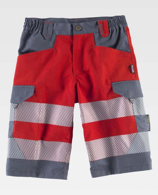 Miliar Ropa Laboral Bermuda combinada y cintas reflectantes segmentadas. Dos bolsos de abertura inclinada en los costados, dos bolsos laterales interiores con cartera de corchete oculto. Dos bolsos traseros con pliegue inferior con cartera de corchete oculto. Dos cintas reflectantes segmentadas termoadhesivas en perneras. Cinta decorativa personalizada en un bolso trasero. Elástico en los laterales de la cintura. Trabillas de diferente color. Cierre de botón metálico y bragueta de cremallera.