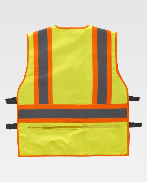 Miliar Ropa Laboral Chaleco en tejido Oxford reflectante-fluorescente con ajustes laterales. Escote a pico y cierre de cremallera. Trabillas de cinta tejida gris, un bolso de plastón con cartera de velcro y otro con sistema de sujeción para emisoras en el pecho. Dos bolsos laterales con fuelle y cierre de cremallera. Bolsillos auxiliares superpuestos con cartera de velcro. Bolso trasero interior con cierre de cremallera. Ajustes laterales con hebillas automáticas. Una banda fluorescente con una cinta reflectante en pecho, espalda y hombros. Ribeteado con bies a contraste. Forro interior de rejilla.