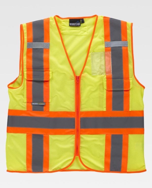 Miliar Ropa Laboral Chaleco de rejilla reflectante-fluorescente con escote a pico y cierre de cremallera. Trabillas de cinta tejida gris, dos bolsos de plastón con cartera de velcro y un bolsillo transparente para identificador personal en el pecho. Una banda fluorescente con una cinta reflectante en pecho, espalda y hombros. Abertura trasera para arnés. Ribeteado con bies a contraste.